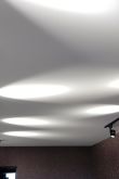 Белый натяжной потолок с черными светильниками