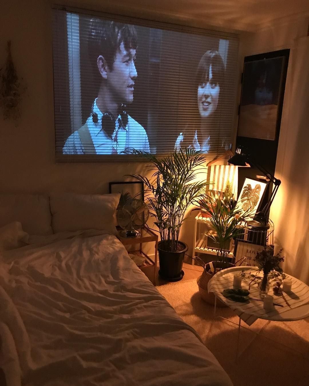 В спальне перед телевизором. Уютная комната с проектором. Уютная комната с телевизором. Уютная комната вечером. Телевизор с фильмом.