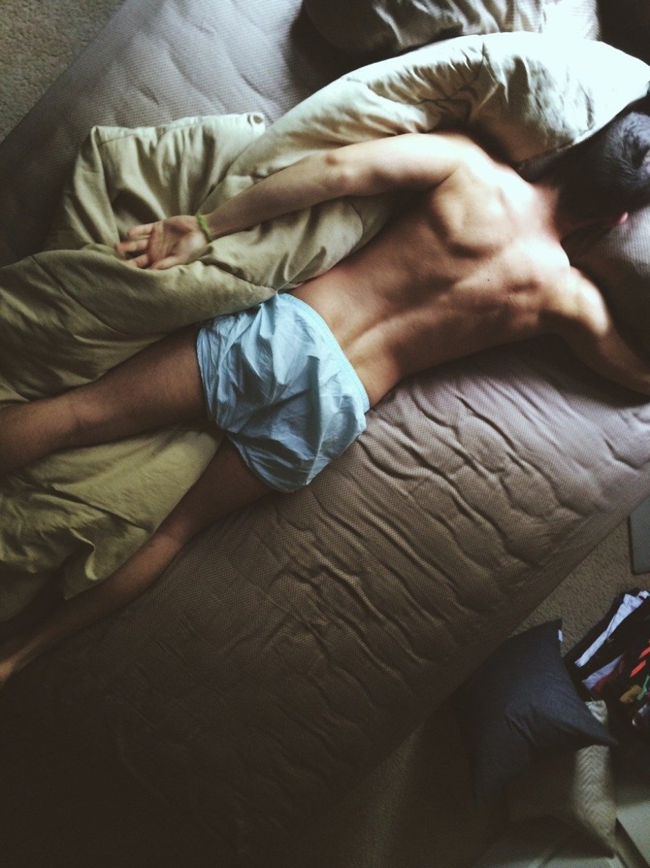 Мужская спина на кровати