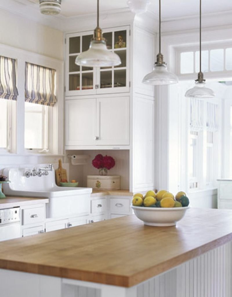 Белая кухня с деревянной столешницей люстра