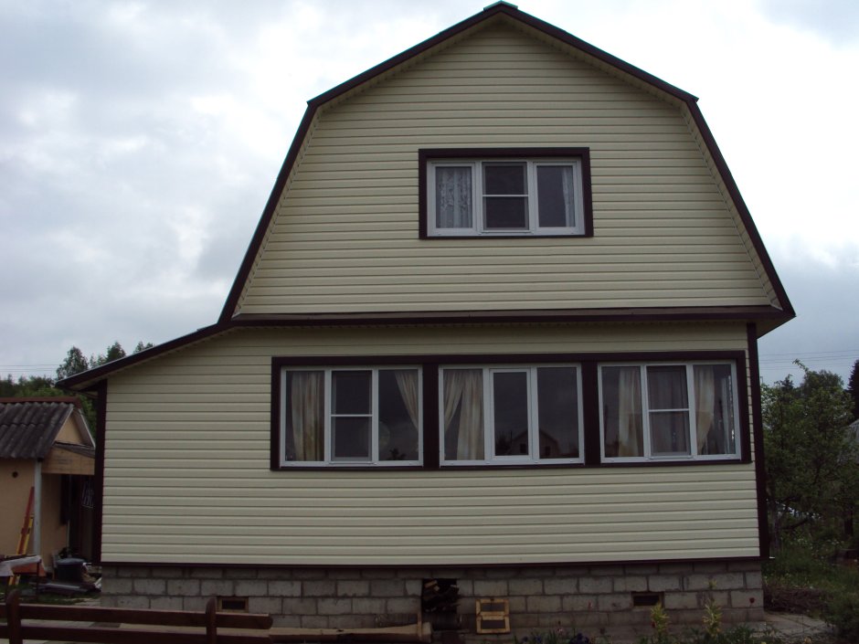 Дом с ломаной крышей обшитый сайдингом