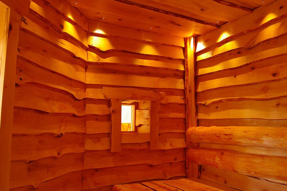Потолок из необрезной доски в деревянном доме из бревна