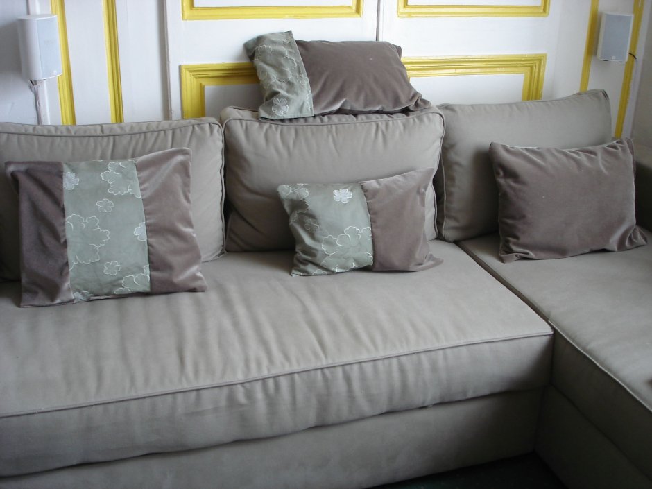 Серый диван с бежевыми подушками