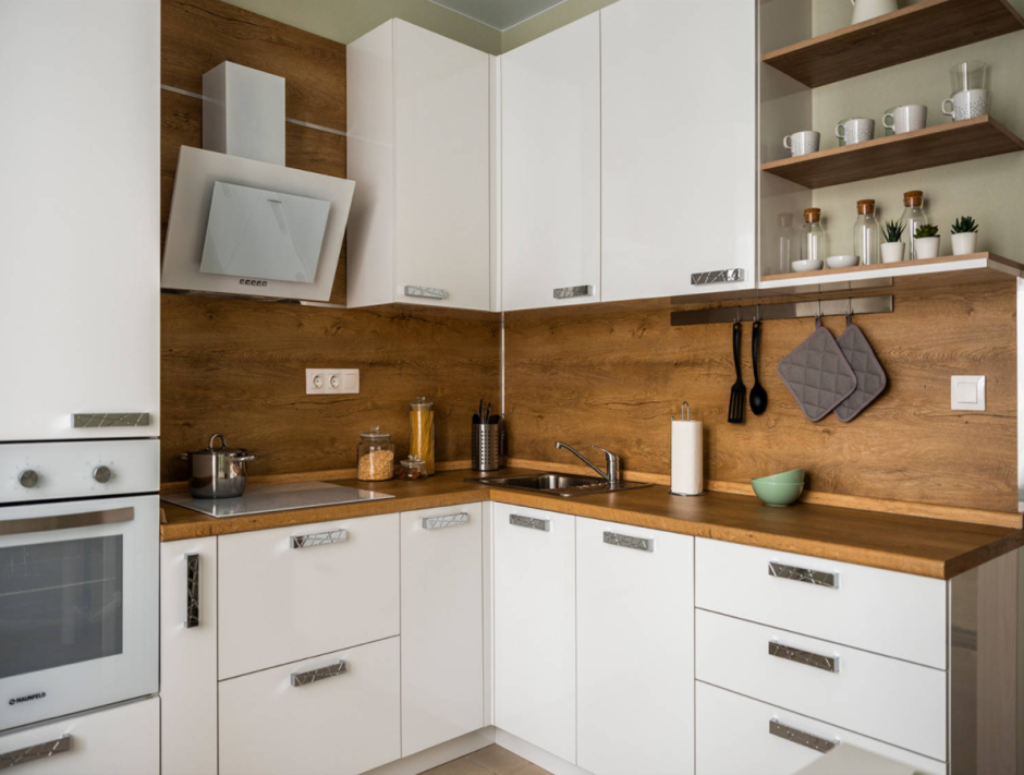 Белая кухня с деревянной столешницей и фартуком