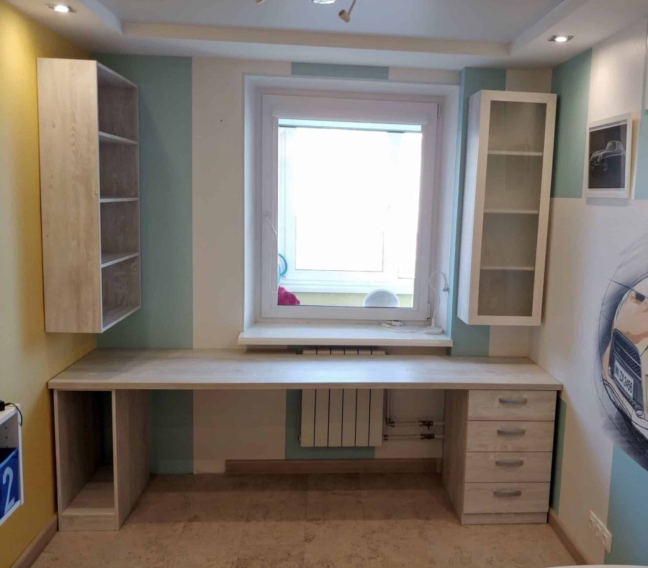 Шкафы со столом возле окна