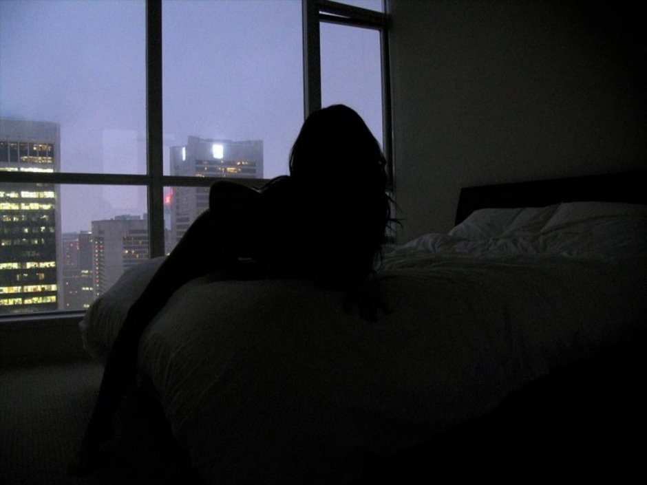 Девушка в постели в темноте