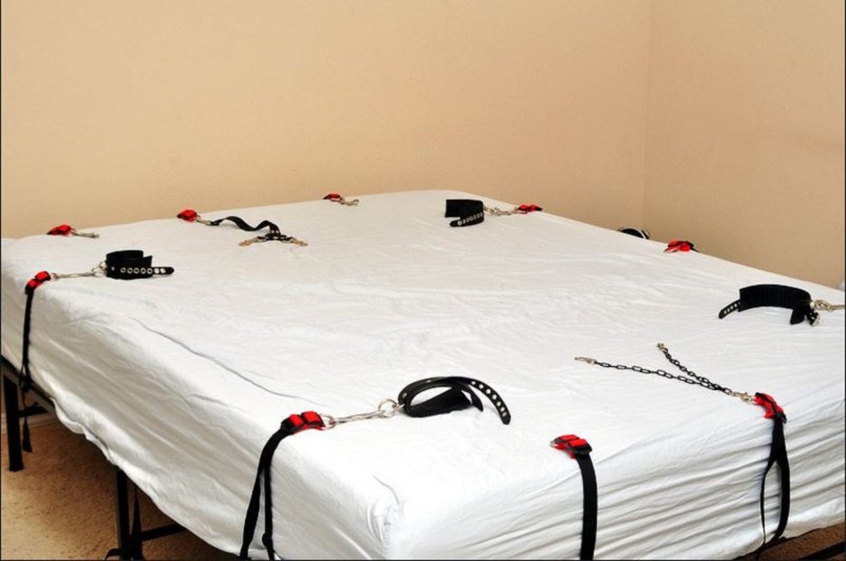 Кровать с цепями и наручниками